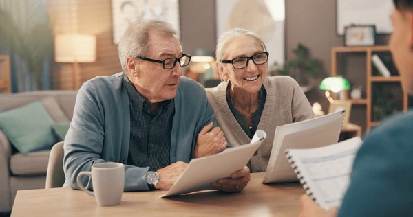 A smiling older couple planning their financial future, symbolizing ease and security